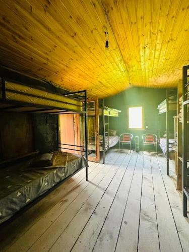 a large room with bunk beds and a wooden floor at Qaldea Resort in Ushguli