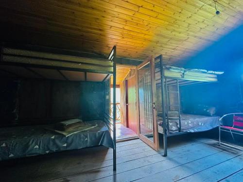 a room with two bunk beds and a wooden ceiling at Qaldea Resort in Ushguli