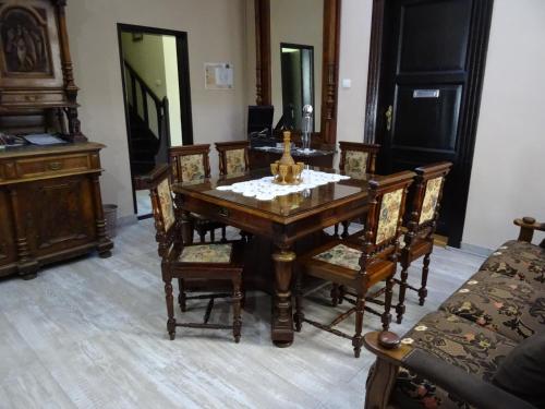 a dining room with a wooden table and chairs at Mia Casa in Novi Sad