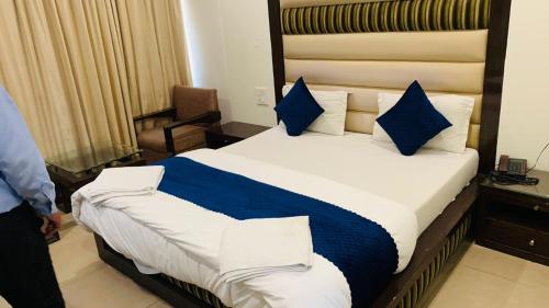 a bed with blue pillows in a hotel room at Hotel Landmark in Chandīgarh