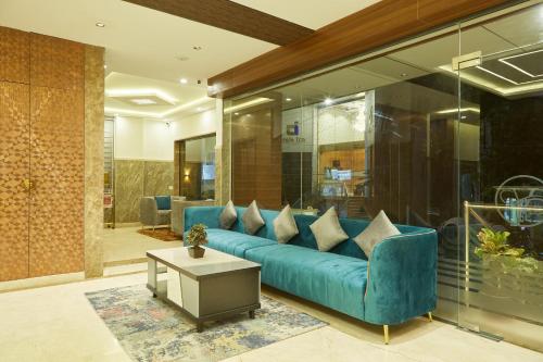 a living room with a blue couch and a table at VOVO PREMIER HOTEL in Bengaluru