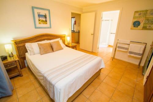 um quarto com uma cama grande num quarto em Sunbird Gardens Villa 3 em Agnes Water