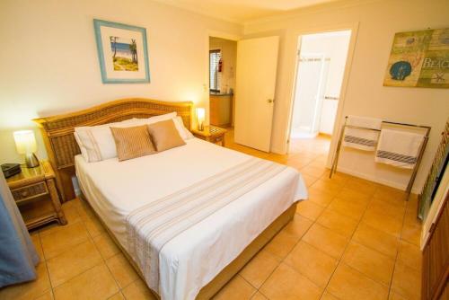 a bedroom with a large bed in a room at Sunbird Gardens Villa 3 in Agnes Water