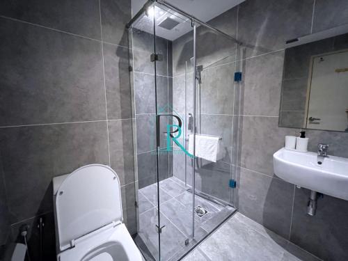 a bathroom with a shower and a toilet and a sink at Restful Respite Tanjung Aru Inifnity Pool 2BR in Kota Kinabalu