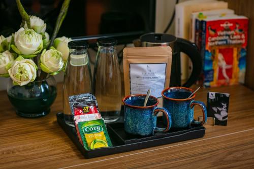 a tray with three coffee mugs on a table at The Sono Hanoi Hotel in Hanoi