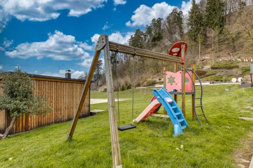 einen Spielplatz mit Rutsche im Gras in der Unterkunft Honeycomb Chalets And Apartments Mozirje - Happy Rentals in Mozirje