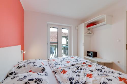 a bedroom with a bed with a floral comforter at Honeycomb Chalets And Apartments Mozirje in Mozirje
