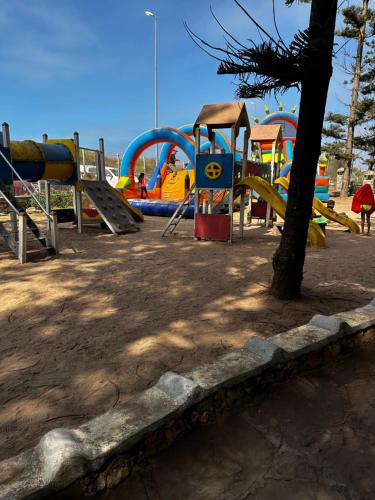 a park with a playground with a slide and a play structure at Étage RDC villa vu sur mer avec jardin in El Jadida