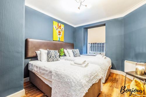 - une chambre avec 2 lits et des murs bleus dans l'établissement Trocadero Suite - Central-Royal Mile Castle, à Édimbourg