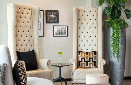 a living room with two chairs and a table at Leonardo Royal Hotel Cologne Bonn Airport in Cologne
