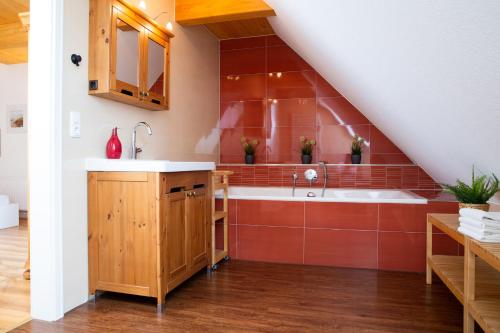 a kitchen with a sink and red tiles at Haus im Felde Whg 6 in Fehmarn