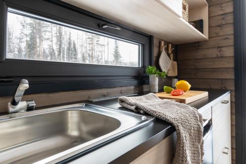 a kitchen with a sink and a window at Arctic Circle Beach House in Meltosjärvi