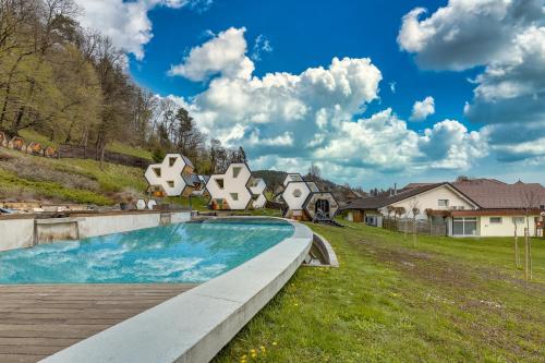 a swimming pool in a yard with houses at Honeycomb Chalets And Apartments Mozirje in Mozirje