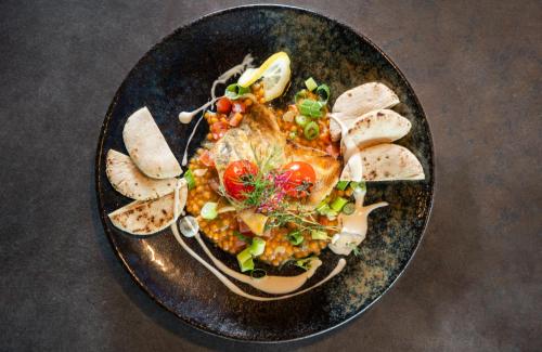 a plate of food with vegetables and bread on a table at Leonardo Royal Hotel Cologne Bonn Airport in Cologne