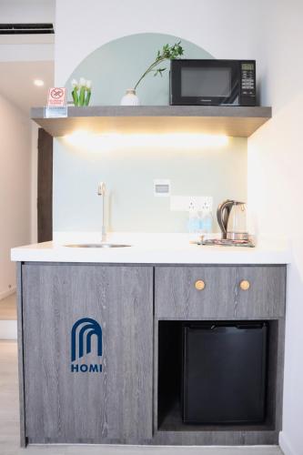 a kitchen counter with a microwave and a sink at Homi Oasis at KK Times Square 和逸绿洲 in Kota Kinabalu