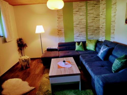 a living room with a blue couch and a table at Ferienwohnung Familie Fiechtl in Fügenberg