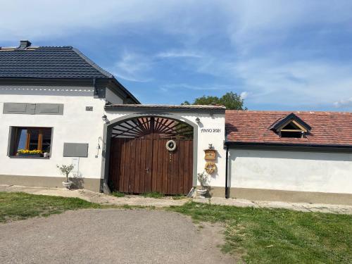 una casa bianca con una porta marrone in legno di SECRET GARDEN LKÁŇ 