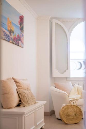 a white room with a chair and a window at House on the rock in Positano