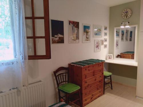 スーバラにあるExplore Aegina Islandのデスク、椅子2脚、ドレッサーが備わる客室です。