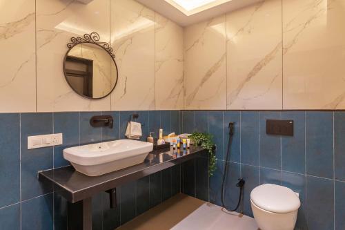 un baño con lavabo e inodoro en Villa Sereno by StayVista - An elegant and entertaining retreat featuring a swimming pool, outdoor jacuzzi, modern interiors, and a snooker table, en Alibaug