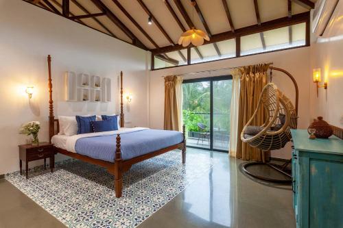 Un dormitorio con una cama y un columpio. en Villa Sereno by StayVista - An elegant and entertaining retreat featuring a swimming pool, outdoor jacuzzi, modern interiors, and a snooker table, en Alibaug