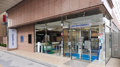una tienda frente a un edificio con puertas de cristal en Toyoko Inn Iwakuni eki Nishi guchi, en Iwakuni