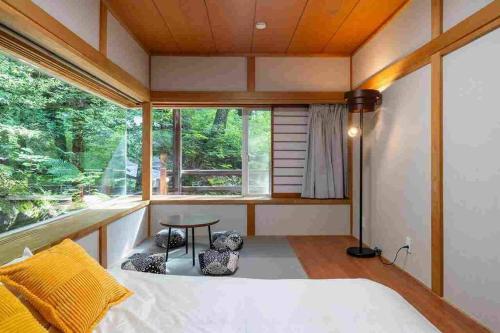 嬬恋村にあるS-villa Karuizawa - Princeland -のベッドルーム1室(窓の前にテーブルとベッド付)