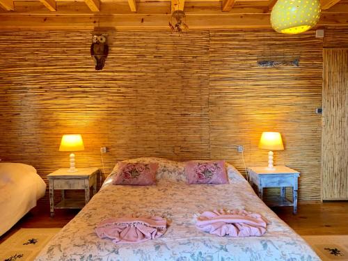 a bedroom with a bed with pink sheets and two lamps at Large Bungalow with Sea View in Kabak Bay, Ölüdeniz in Fethiye
