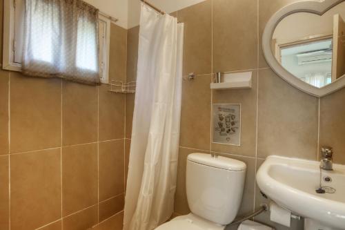 La salle de bains est pourvue de toilettes, d'un lavabo et d'un miroir. dans l'établissement Ilha Azul House, à Ponta do Ouro