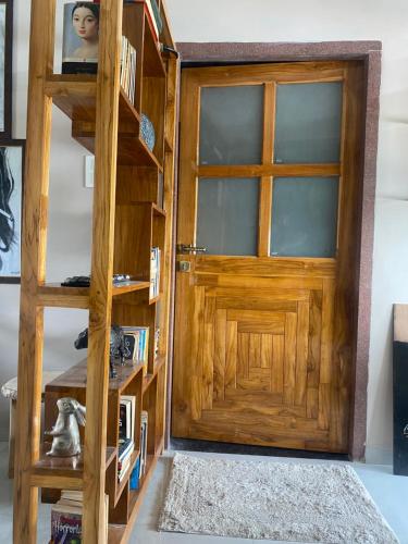 a room with a wooden door and a book shelf at The Retreat in Jhunjhunūn