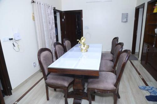 a dining room with a white table and chairs at Fortune Home Service Apartment 3Bhk,B-57 Sarita Vihar in New Delhi