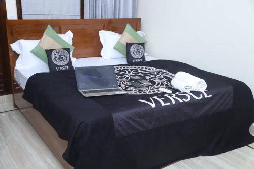 a black and white bed with a laptop on it at Fortune Home Service Apartment 3Bhk,B-57 Sarita Vihar in New Delhi
