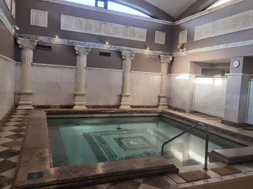 a pool in a building with columns at Belchin Garden SPA&Wellness in Belchin