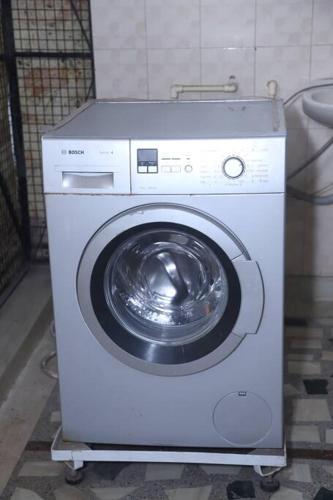 a white washing machine sitting in a room at Fortune Home Service Apartment 3Bhk,B-57 Sarita Vihar in New Delhi