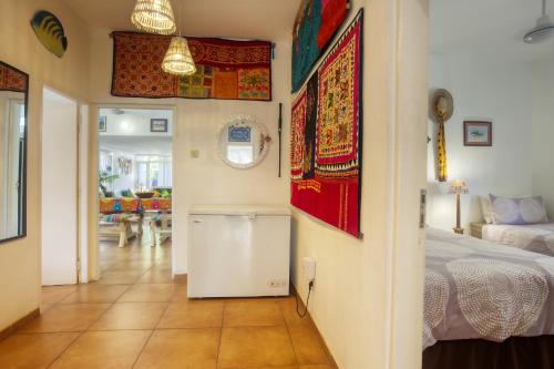 a bedroom with a bed and a room with a table at Ilha Azul House in Ponta do Ouro