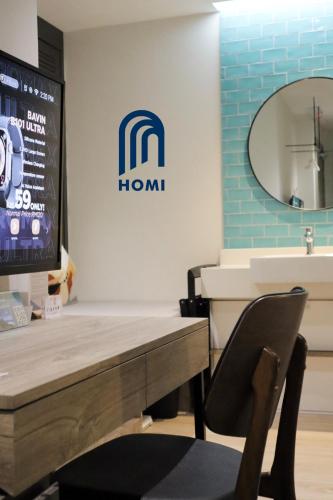 a room with a table and a chair and a mirror at Homi Breeze at Sutera Avenue 和逸微风 in Kota Kinabalu