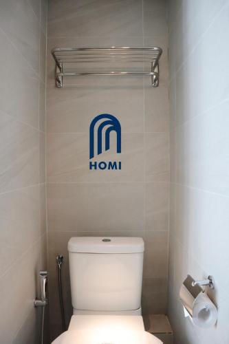 a bathroom with a toilet with a hilton sign on the wall at Homi Breeze at Sutera Avenue 和逸微风 in Kota Kinabalu