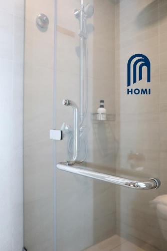 a glass shower door with a hilton sign on the wall at Homi Breeze at Sutera Avenue 和逸微风 in Kota Kinabalu