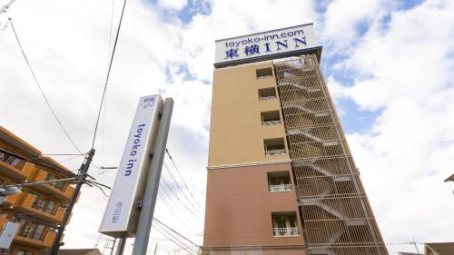 a building with a sign on top of it at Toyoko Inn Chofu Keio sen Fuda eki in Chofu