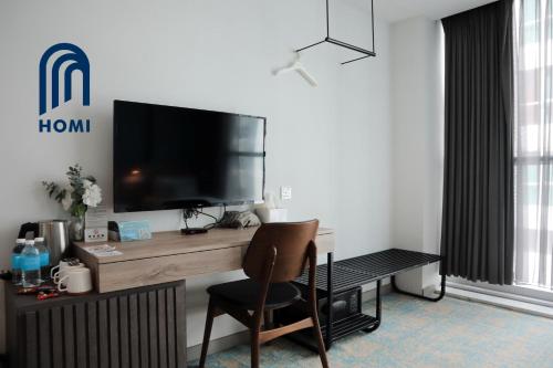 a room with a desk with a television and a chair at Homi Breeze at Sutera Avenue 和逸微风 in Kota Kinabalu