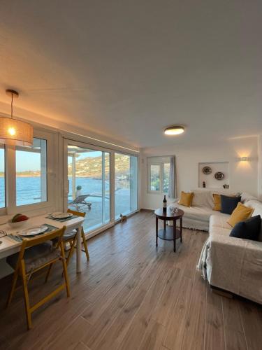 a living room with a couch and a table at Seafront Villa Polyxene in Keratea