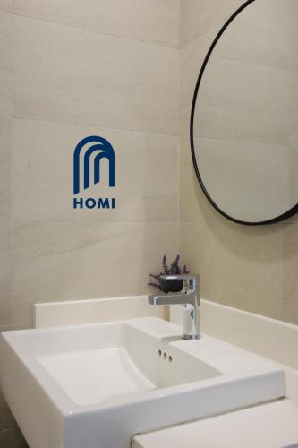 a bathroom with a white sink and a mirror at Homi Breeze at Sutera Avenue 和逸微风 in Kota Kinabalu