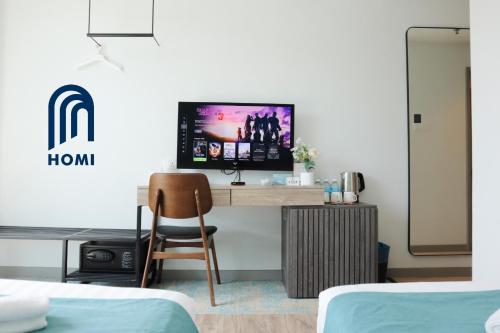 a bedroom with a desk with a tv and a chair at Homi Breeze at Sutera Avenue 和逸微风 in Kota Kinabalu