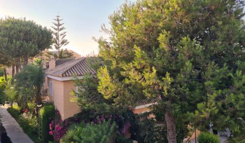 una casa con árboles y flores delante de ella en Vera Vistas: Espléndido ático con terraza de 55m2 en Vera