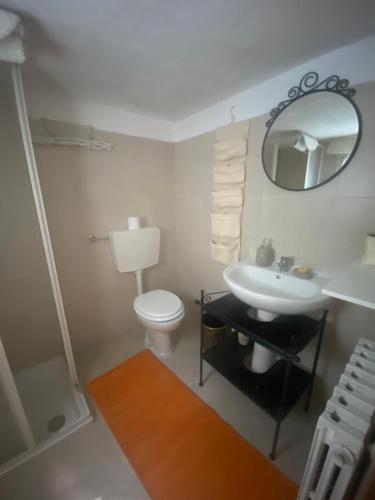 ein Badezimmer mit einem Waschbecken, einem WC und einem Spiegel in der Unterkunft Nicoletta Spirito del Tibet in San Leo