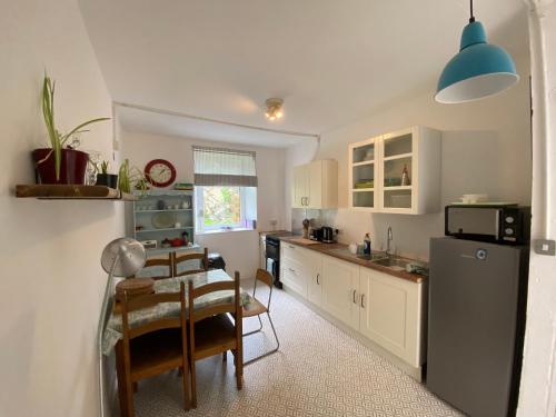 a kitchen with a table and a dining room at 19 Headlands Cottage in Coverack