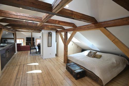 ein Schlafzimmer mit einem Bett in einem Zimmer mit Holzdecken in der Unterkunft Altstadtjuwel in Celle