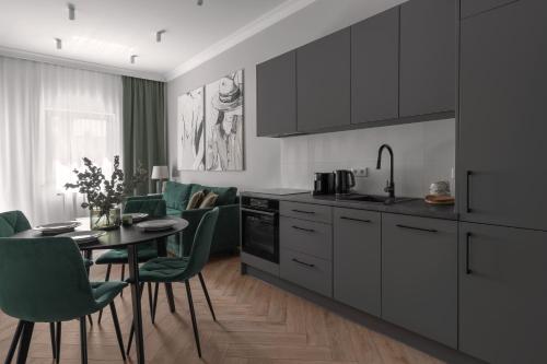 a kitchen and dining room with a table and chairs at APARTIO ROOMS Gliwice in Gliwice