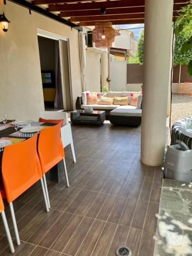 an outdoor patio with orange chairs and a couch at Villa Carletti à 3min des plages (7pers. - 3ch.) in Oletta