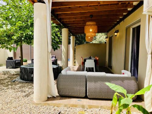 a patio with a couch and a table on a porch at Villa Carletti à 3min des plages (7pers. - 3ch.) in Oletta